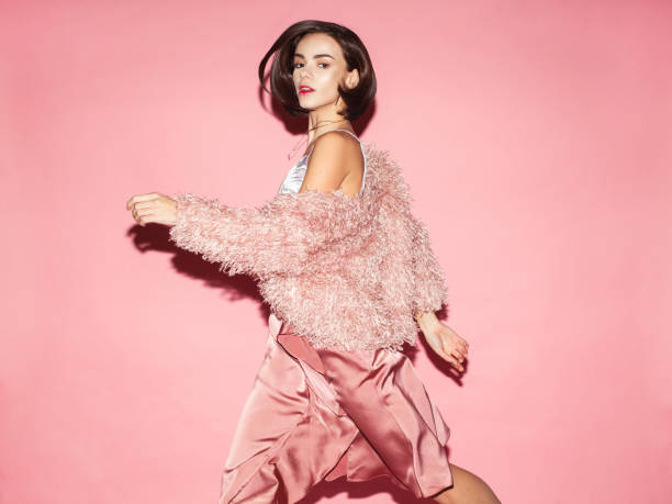 Woman modeling stylish pink attire against a pink backdrop, illustrating key aspects of fashion photography.