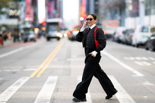 A fashionable person crosses a city street, showcasing a trendy, innovative style.